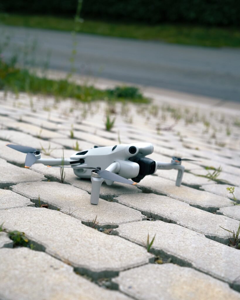 Drone DJI Mini posé au sol avant une prise de vue aérienne