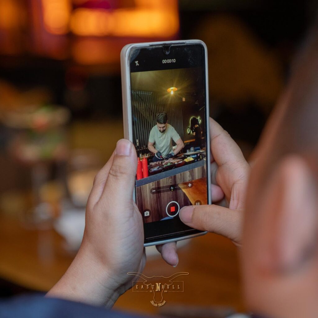 Tournage au smartphone du chef en salle dans un steakhouse