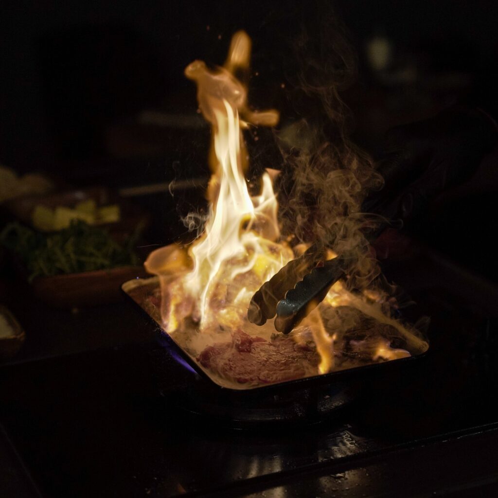 Steak flambé à la pince en cuisine ouverte
